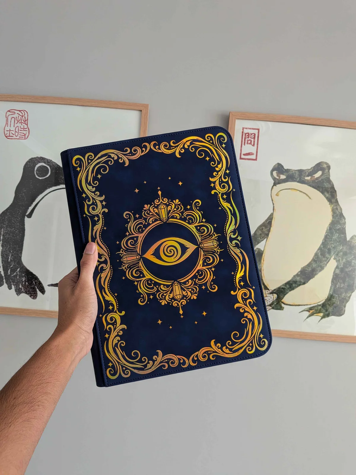 Astral Vision binder held in front of framed wall art