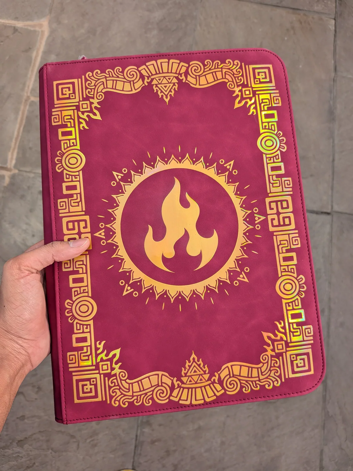 Angled Sunfire binder held outdoors against stone
